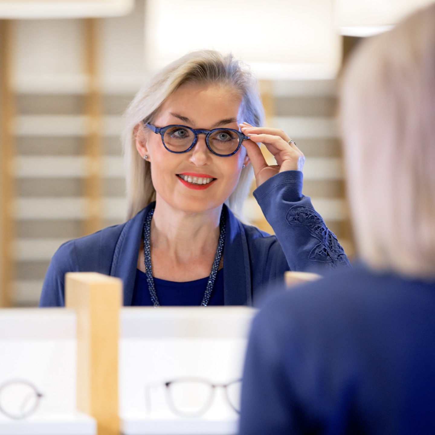 Eine Frau probiert eine Brille bei Optometrie Cagnolati an.
